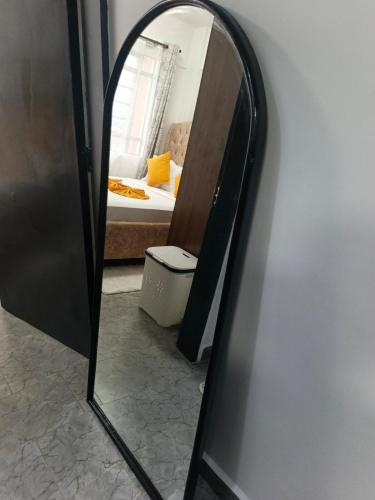 a mirror in a room with a bed and a bedroom at EnE Homes in Kisumu