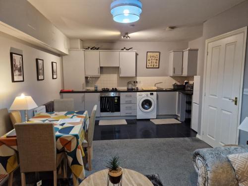a kitchen and living room with a table and a dining room at Morden 2 Bed Apartment, with parking near city centre in Coventry