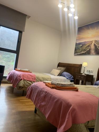 a bedroom with two beds and a painting on the wall at Casa Ferran, amplias habitaciones y apartamentos de montaña in Valcarlos