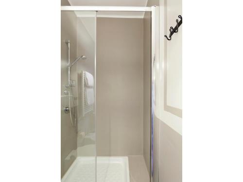 La salle de bains est pourvue d'une douche avec une porte en verre. dans l'établissement Apartment Via Farina, à Rome