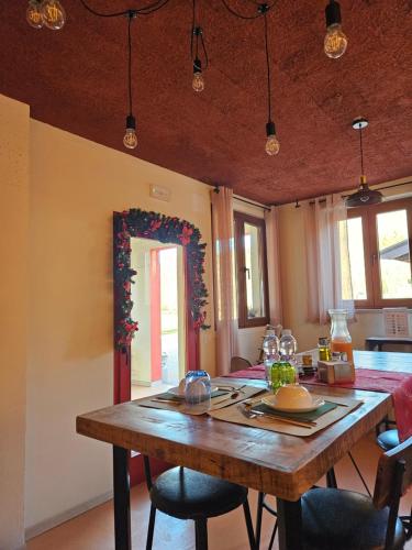 una sala da pranzo con tavolo in legno e sedie di Dolcevita guest house a Torreano