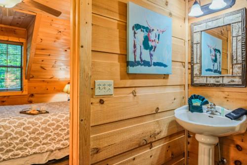 a bathroom with a sink and a bed at Goonies Cove - Spacious 4BR Cabin Arcade, Pool Table & Hot Tub! in Sevierville