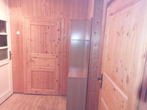 a refrigerator in a room with a wooden wall at Pension Rippachtal 2 in Lützen