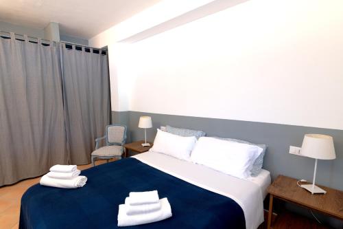 a bedroom with a blue and white bed with towels on it at Verde Blu Scirocco Lake Front Apartment Trevignano Romano in Rome