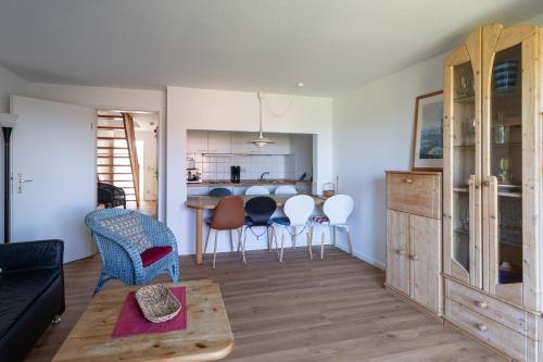 a living room and kitchen with a table and chairs at Haus Stranddüne, Whg 6 in Cuxhaven