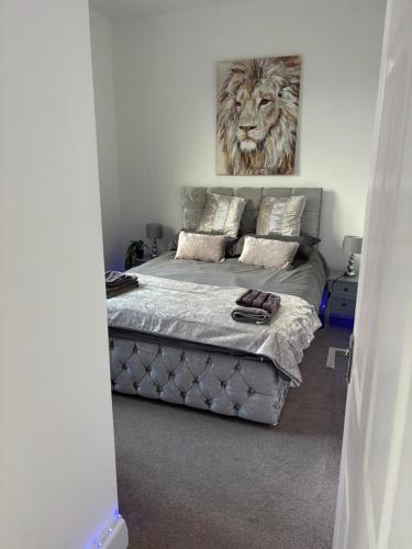 a bedroom with a bed with a lion painting on the wall at Safari Cottage, Kidderminster in Kidderminster