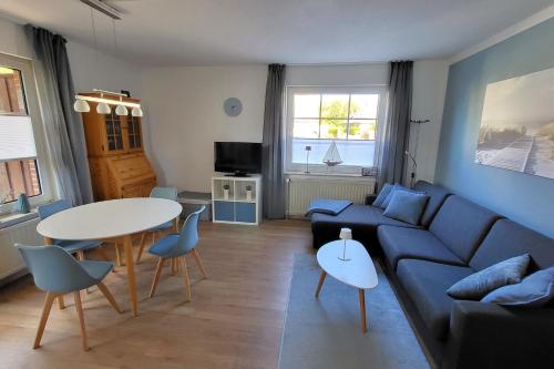 a living room with a blue couch and a table at Haus Hinter der Kirche in Döse