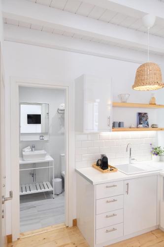 a white kitchen with a sink and a toilet at Galaxidaki στην Πλατεία in Galaxidi