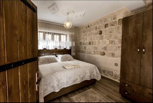 a bedroom with a bed and a stone wall at Birsen Hanım Konağı in Mardin