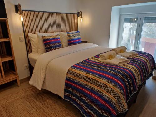 una camera da letto con un letto grande con asciugamani sopra di Cozy Apartment Elvas II a Elvas
