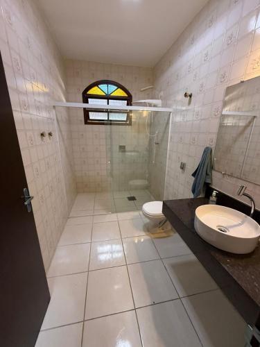 a bathroom with a shower and a toilet and a sink at Casa Itaguá in Ubatuba