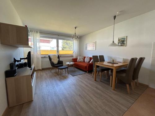 a living room with a red couch and a table at Haus Vogelsand, App 324 in Cuxhaven