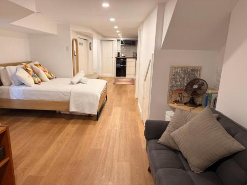 a living room with a bed and a couch at Lower level newly renovated studio apartment in central downtown location in Toronto