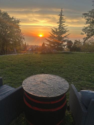 a table in a field with a sunset in the background at Casa Mido Badacsony in Badacsonytomaj