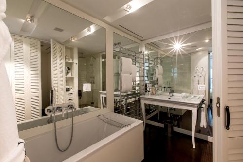 a bathroom with a tub and a shower and a sink at Magna Pars l'Hotel à Parfum, Small Luxury Hotels of the World in Milan