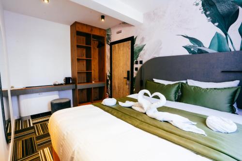 a bedroom with two swans towels on a bed at PARK INN, Bugojno in Bugojno
