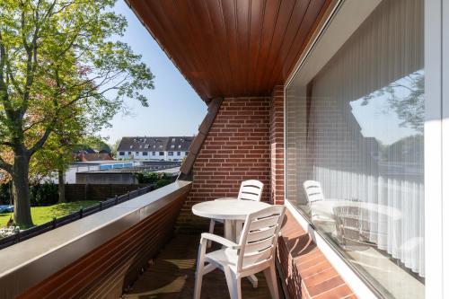 a balcony with a table and chairs on it at Haus Luv und Lee Wohnung 26 in Döse