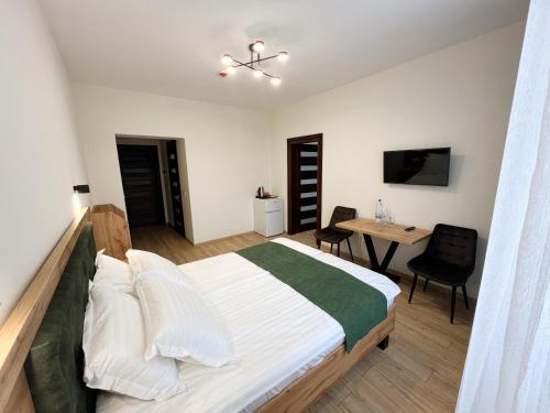 een slaapkamer met een bed, een bureau en een tafel bij Джерело in Brody