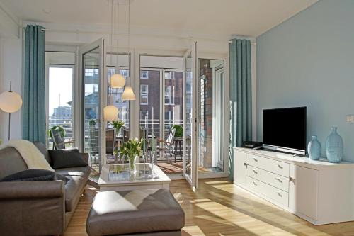 a living room with a couch and a tv at Haus Yachthafen, Whg 4 in Cuxhaven