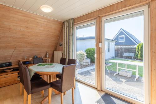 a dining room with a table and a large window at Seegras in Cuxhaven