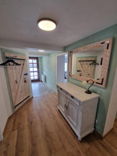 a room with two doors and a table with a mirror at Ferienwohnung Braun in Longkamp