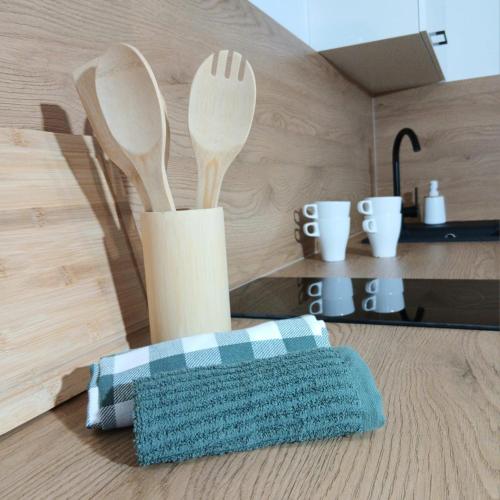 a wooden spoon and fork holder on a table at Apartament Kułachówka - Sielskie wakacje na wsi, własny sad, pasieka i ogród in Leśnica