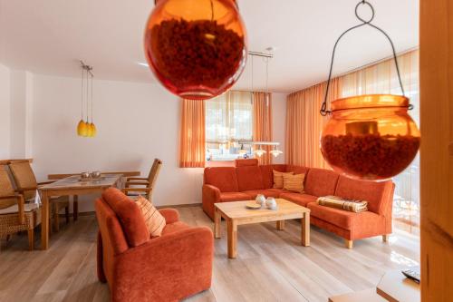 a living room with orange furniture and large vases at Haus Weser, Whg 2 in Döse