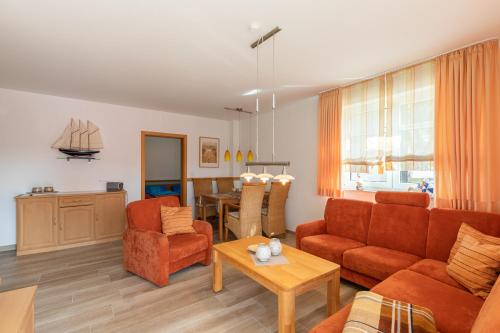 a living room with a couch and chairs and a table at Haus Weser, Whg 2 in Döse
