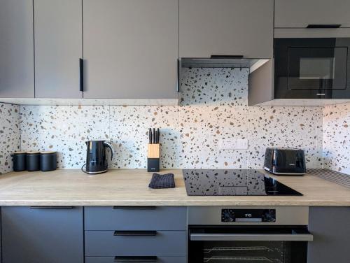 a kitchen with white cabinets and a counter top at Saffron Court Apartments in High Wycombe