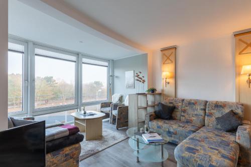 a living room with a couch and a table at Kurpark Residenz, App 219b in Döse