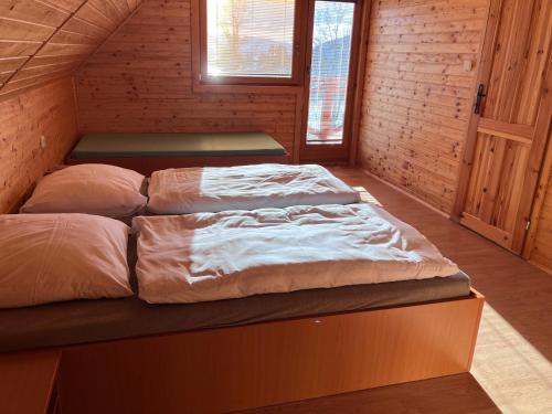a bedroom with two beds in a wooden cabin at Barbora chata in Nitrianske Rudno