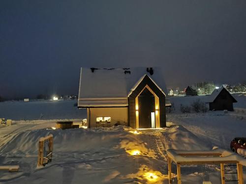 a small church with lights in the snow at night at Kącik Na Dolinie in Groń