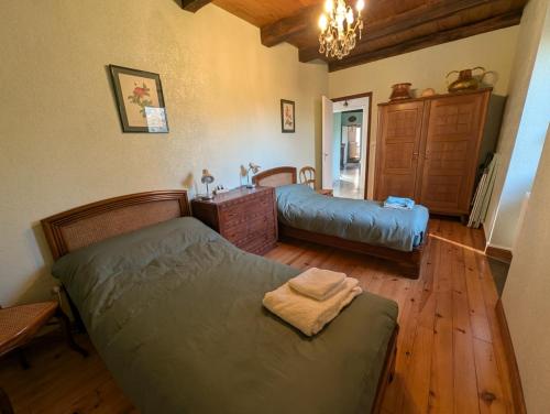 een slaapkamer met 2 bedden en een wastafel. bij Gîte en pierre maison quercynoise in Vaylats