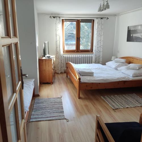 a bedroom with a large bed and a window at Pod Limbą in Jurgów