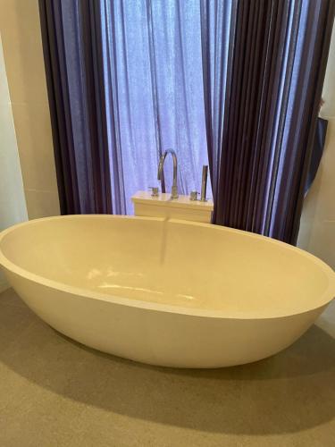 a large bath tub sitting in front of a window at Villa Elina 09 in Badung