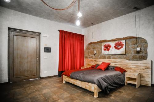 a bedroom with a wooden bed and a red curtain at Agriturismo La Collina in Pitigliano