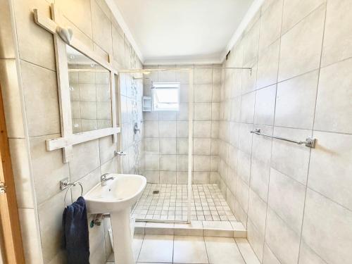 Un baño blanco con lavabo y ducha. en Lyn's Self Catering, en Swakopmund