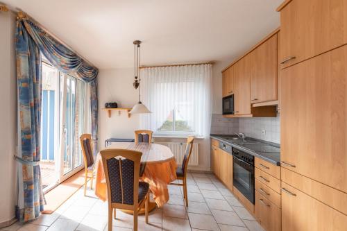 a kitchen with a table and a table and chairs at Haus Meeresrauschen, Whg 1 in Duhnen