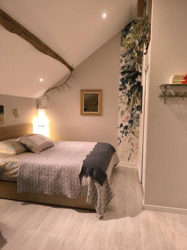 a bedroom with a bed in a room at Le petit grenier de la Quoiqueterie in Vieille-Église-en-Yvelines