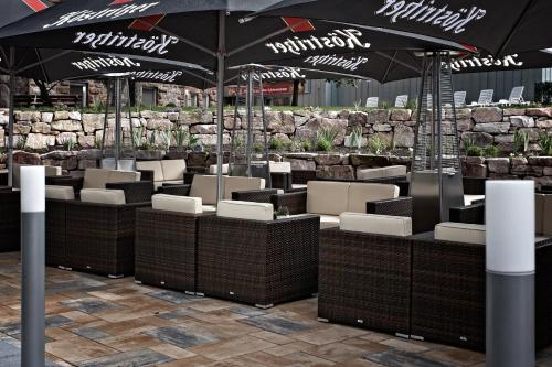 a row of tables and chairs with umbrellas at Konsum Berghotel Oberhof in Oberhof