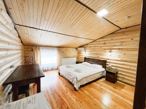 een slaapkamer met een bed in een houten kamer bij Джерело in Brody
