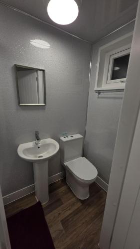 a bathroom with a toilet and a sink at Comfort Lodge in Nottingham