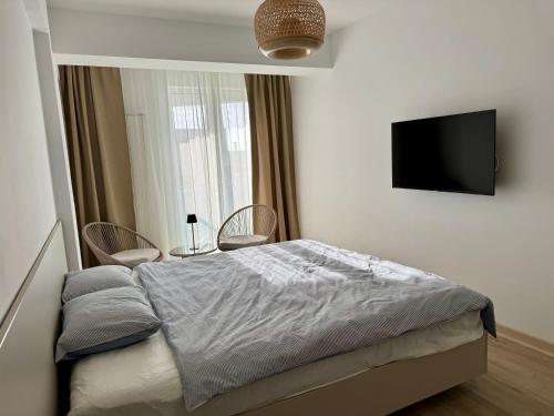 a bedroom with a bed and a flat screen tv at Alezzi Infiniti Resort & SPA - SUNRISE 349 in Năvodari