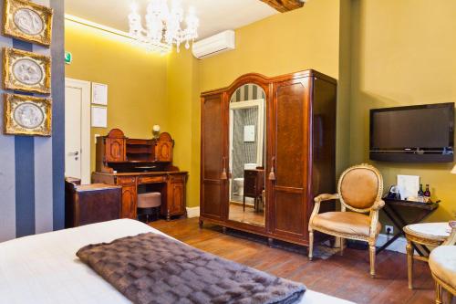 a bedroom with a bed and a desk and a tv at Hotel Diamonds and Pearls in Antwerp