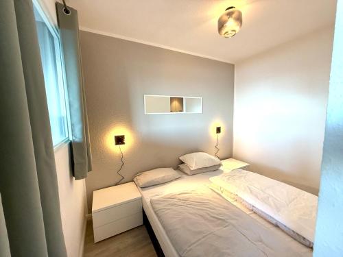 Giường trong phòng chung tại Moderne 3-Zi-Wohnung mit Meerblick direkt am Strand