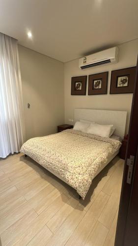 a bedroom with a bed and a air conditioner on the wall at Cosy 1BR with a PUBLIC POOL and WIFI in Ma‘mūrah