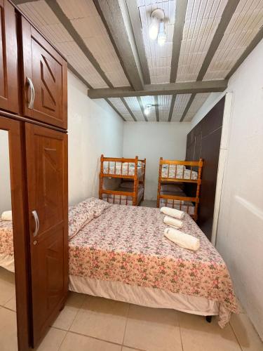 a bedroom with a bed and two wooden chairs at Casa privada no Centro in São Gabriel