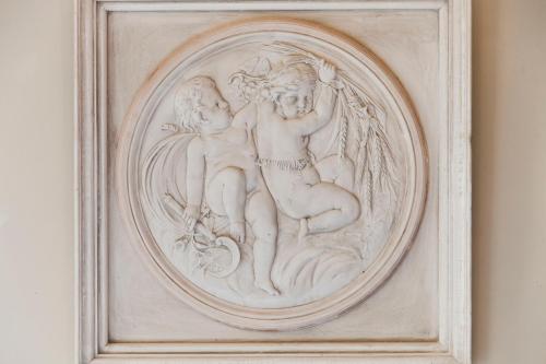 a white carving of two people on a wall at Hotel Diamonds and Pearls in Antwerp