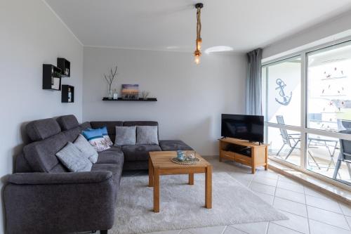 a living room with a couch and a tv at Haus Vogelsand, App 309 in Duhnen
