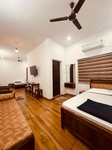 a bedroom with a bed and a ceiling fan at Green Villa Chirackal Gardens in Trichūr